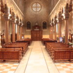 Interno di chiesa con panche in legno pronte per l’installazione di pedane riscaldanti nel 2025
